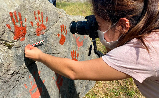 Une archéologue qui photographie des peintures rupestres